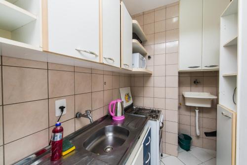 eine kleine Küche mit einer Spüle und einem rosa Gerät in der Unterkunft Acomodações Campinas By Rental in São José