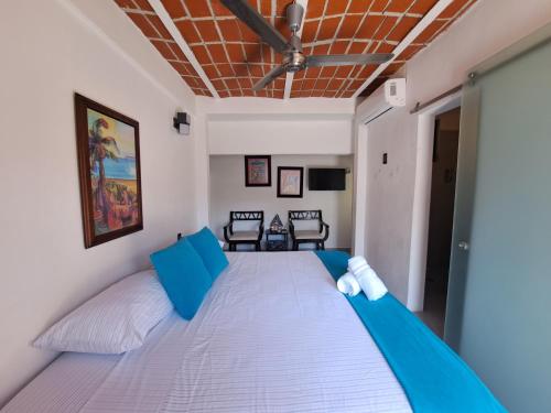 a bedroom with a large white bed with blue pillows at Hotel Diamante Sayulita in Sayulita