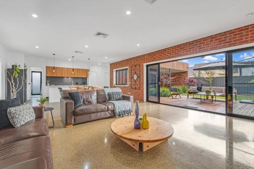 un soggiorno con un divano e un tavolo di Villa Simone - Tranquil Hideaway in the Heart of Echuca a Echuca