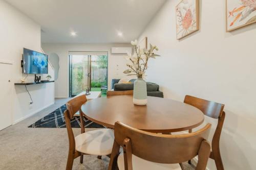 a living room with a table and chairs and a couch at 2BR Stay in the City Free Wi-Fi - Gloucester in Christchurch
