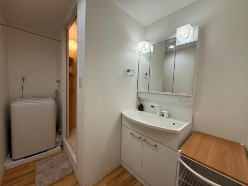 a white bathroom with a sink and a toilet at 要町公寓,无电梯 in Tokyo