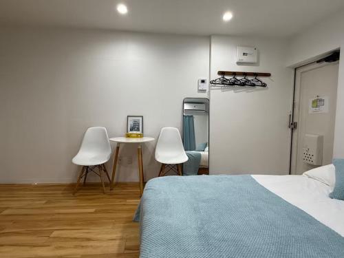 a bedroom with a bed and two chairs and a table at 要町公寓,无电梯 in Tokyo