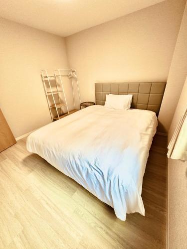 a bedroom with a large white bed in a room at F Hotel 新築アパート 近くに品川と羽田空港 无料駐車場予約必須 in Tokyo