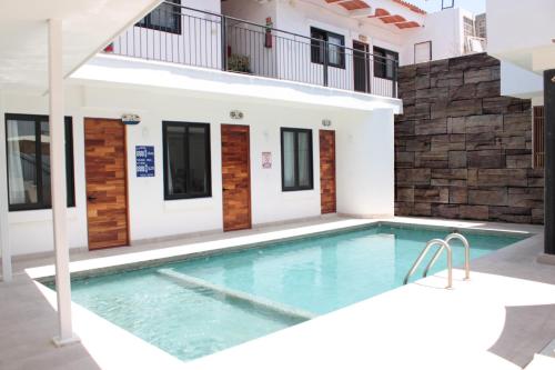 a villa with a swimming pool in front of a house at Hotel Diamante Sayulita in Sayulita