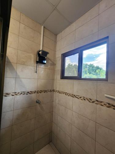 a bathroom with a shower with a window at Cozy, Quiet & Spacious 4bd 3 bth Full Home Gated Community in Los Algarrobos