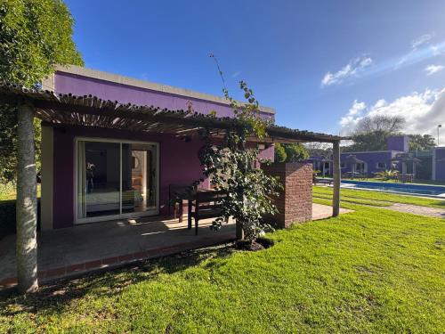 a purple house with a bench in a yard at Villa La Soñada in Miramar