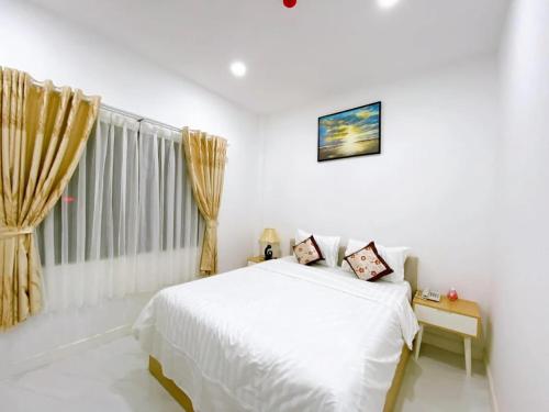 a white bedroom with a bed and a window at Hoàng Gia Hotel Royal in Kim Bảng