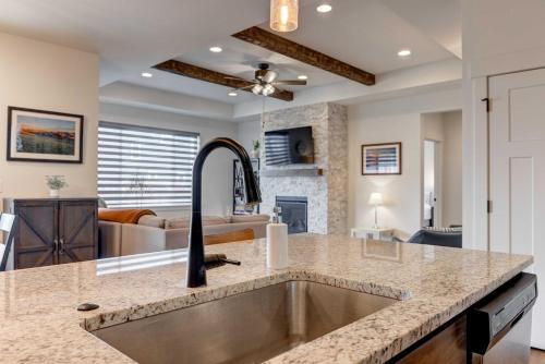 a kitchen with a sink and a living room at Scenic Modern Home with Private Patio & Fireplace in Belgrade