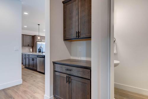 a kitchen with wooden cabinets and a sink at Scenic Modern Home with Private Patio & Fireplace in Belgrade