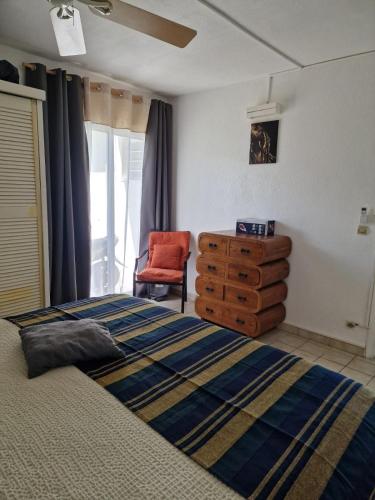 a bedroom with a bed and a dresser and a chair at Beautiful F2 in a blue beach residence in Oyster Pond