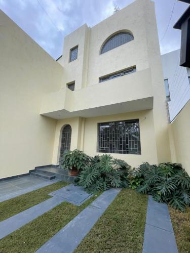 a large white house with plants in front of it at Apartamento completo planta baja Colonia Moderna in Guadalajara