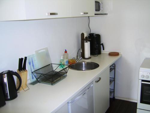 a kitchen counter with a sink and a microwave at Nikol Apartments in Berlin
