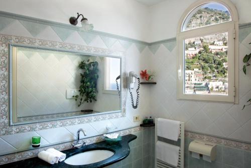 a bathroom with a sink and a mirror at Hotel Reginella in Positano