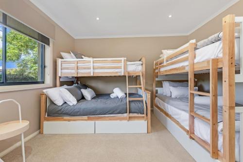 a bedroom with two bunk beds and a desk at The Great Escape - Echuca Holiday Homes in Moama
