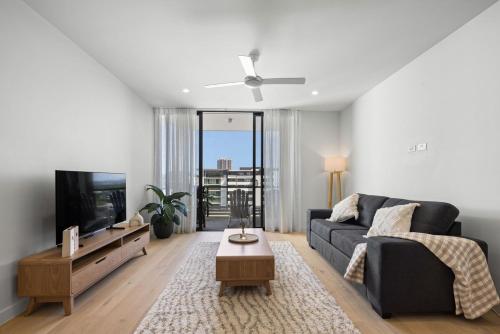 a living room with a couch and a tv at Modern Beachside Oasis 1BR Apartment Free Wi-Fi in Gold Coast