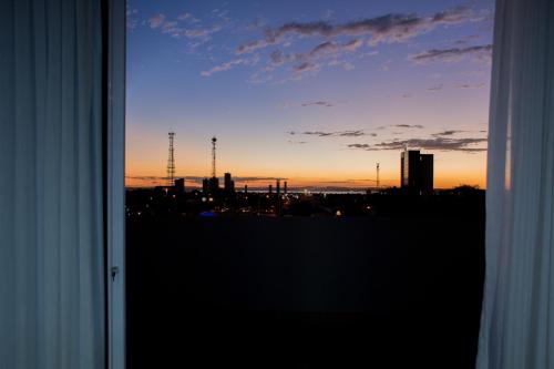 a view of a city at sunset from a window at Select Hotel in Palmas