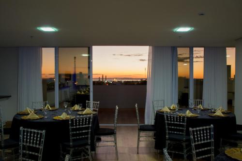 a dining room with tables and chairs with the sunset at Select Hotel in Palmas