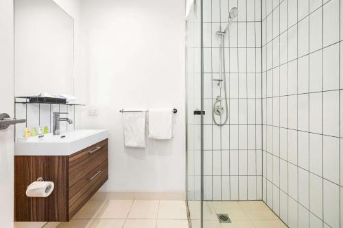a bathroom with a shower and a sink at Comfort Apartments Box Hill in Box Hill