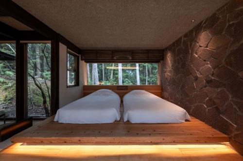 two beds in a room with a window at 奥武雄温泉　風の森 in Ureshino