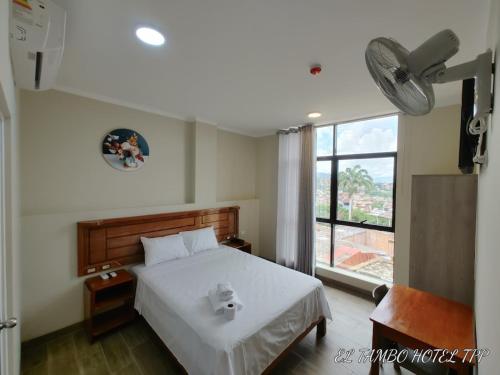 a bedroom with a white bed and a window at Hotel El Tambo de Tarapoto-Perú in Tarapoto