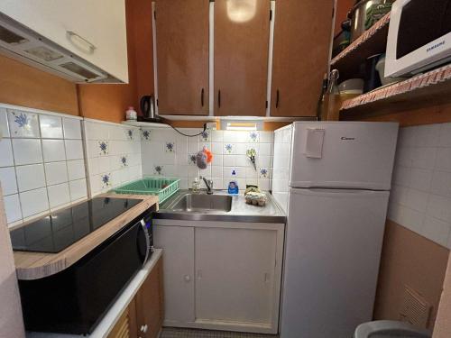 une petite cuisine avec un évier et un réfrigérateur dans l'établissement Studio côtier 3/4 couchages avec parking - FR-1-224C-349, à Saint-Jean-de-Monts