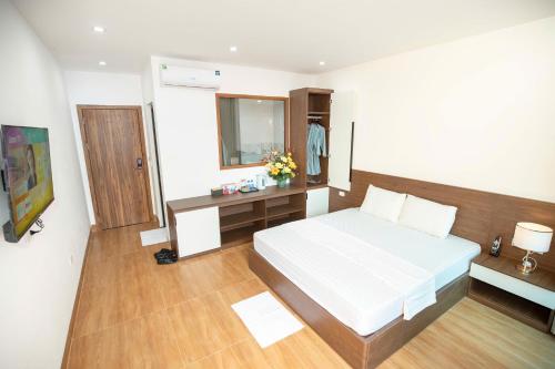 a bedroom with a bed and a desk and a mirror at Flamingo ibza in Gò Ba Quần