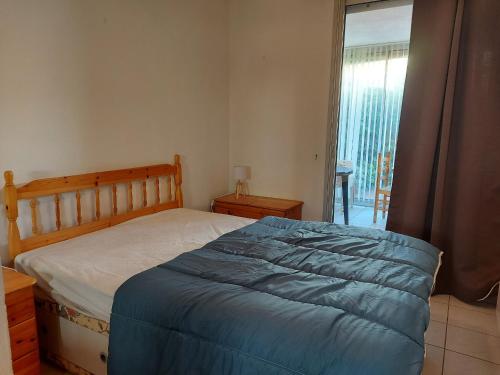 une chambre avec un lit avec une couverture bleue dans l'établissement Appartement 4 pers avec terrasse, piscine et parking sécurisé - FR-1-776-137, à Argelès-sur-Mer