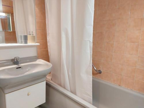 une salle de bain avec un lavabo et un rideau de douche dans l'établissement Appartement 4 pers avec terrasse, piscine et parking sécurisé - FR-1-776-137, à Argelès-sur-Mer