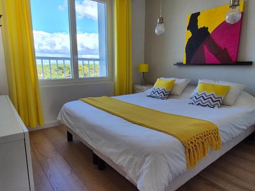 - une chambre avec un grand lit, des murs jaunes et des fenêtres dans l'établissement Superbe Appartement Rénové 2 Chambres Face Mer - FR-1-323-577, à Saint-Jean-de-Monts