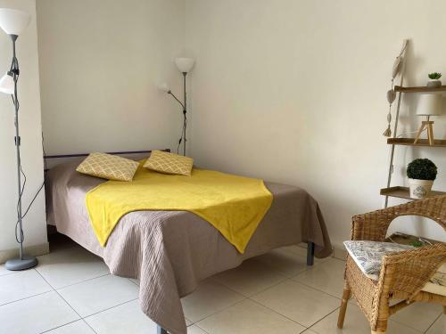 une chambre avec un lit avec une couverture jaune dessus dans l'établissement Studio rénové avec balcon et WIFI à Balaruc-les-Bains - FR-1-553-303, à Balaruc-les-Bains
