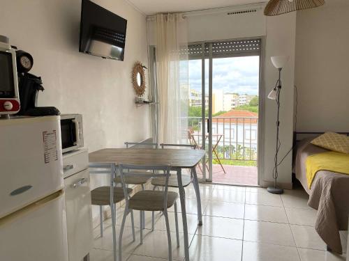 Il comprend une petite cuisine avec une table et une chambre. dans l'établissement Studio rénové avec balcon et WIFI à Balaruc-les-Bains - FR-1-553-303, à Balaruc-les-Bains
