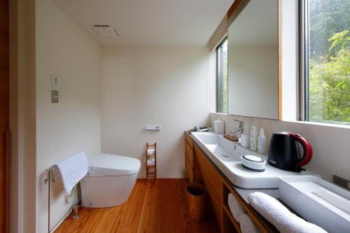 a bathroom with a sink and a toilet and a window at 奥武雄温泉　風の森 in Ureshino