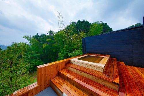 a hot tub sitting on top of a wooden deck at 奥武雄温泉　風の森 in Ureshino