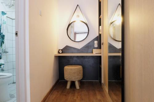 a bathroom with a round mirror and a stool at Kananta Home in Bongkar 2