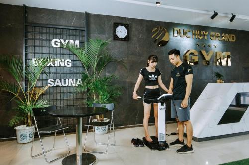 a man and a woman standing next to a table at Duc Huy Grand Hotel and Spa in Lao Cai