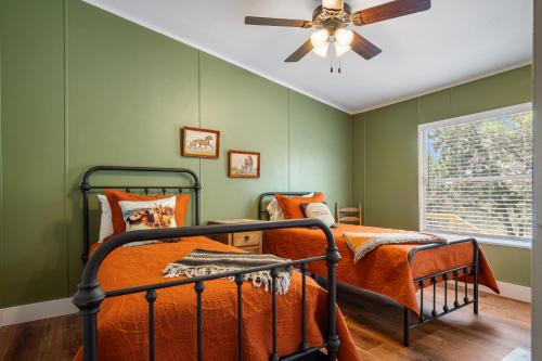 a bedroom with green walls and a bed with a fan at Tejas Hills of Pipe Creek in Pipe Creek
