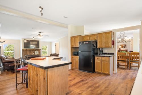 a kitchen with wooden cabinets and a black refrigerator at Tejas Hills of Pipe Creek in Pipe Creek