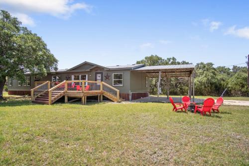 a house with a deck and chairs in the yard at Tejas Hills of Pipe Creek in Pipe Creek