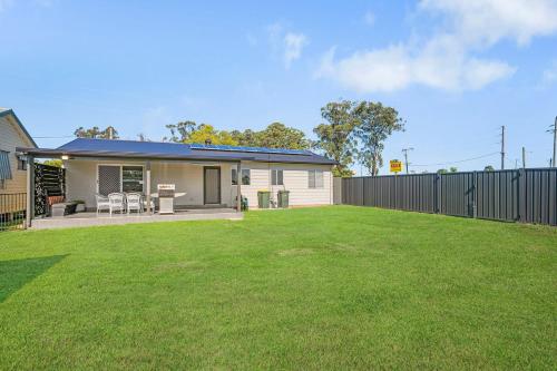 a house with a lawn in front of it at Kew Golf Shack in Kew