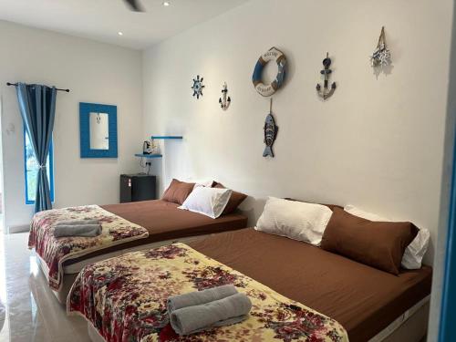 a bedroom with two beds and decorations on the wall at Cabana Chalet Cherating in Cherating