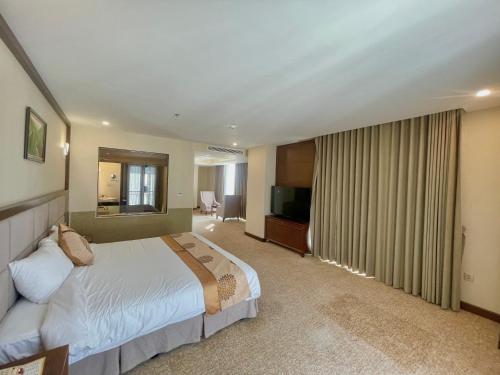 a hotel room with a bed and a television at Duc Huy Grand Hotel and Spa in Lao Cai