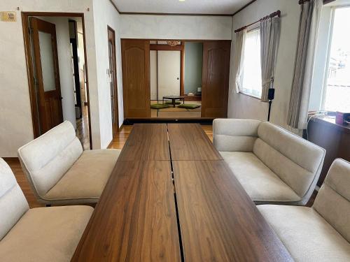 a living room with a wooden table and chairs at ritomaru house iki ashibe in Iki