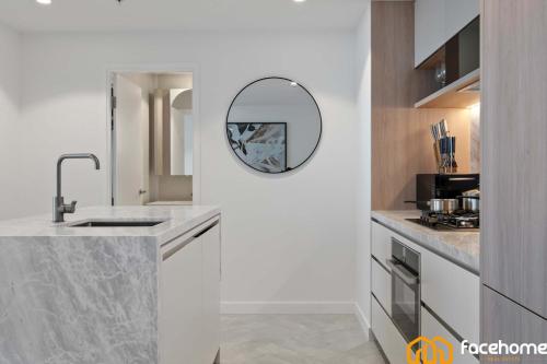 a kitchen with a sink and a mirror on the wall at City Luxury Stay River & City Access in Brisbane