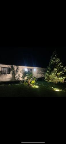 a house with lights in a yard at night at Containerhaus in Carlos Barbosa