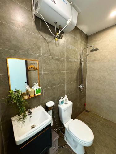 ein Badezimmer mit Toilette, Waschbecken und Dusche in der Unterkunft BB Homestay in Thôn Trường Giang