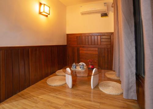 a dining room with a glass table and three chairs at 张家界星河清梦民俗客栈 in Zhangjiajie