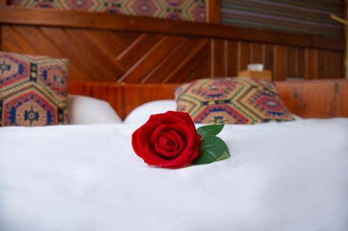 a red rose sitting on top of a bed at 张家界星河清梦民俗客栈 in Zhangjiajie
