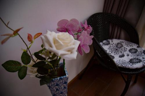 a vase with flowers in it next to a chair at 张家界星河清梦民俗客栈 in Zhangjiajie