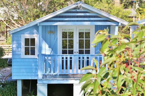 a blue play house with a porch at Cottage 3 Hyams Beach Seaside Cottages in Hyams Beach