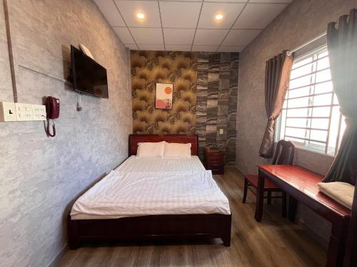 a bedroom with a bed and a tv in it at Trung Hau Hotel in Can Tho